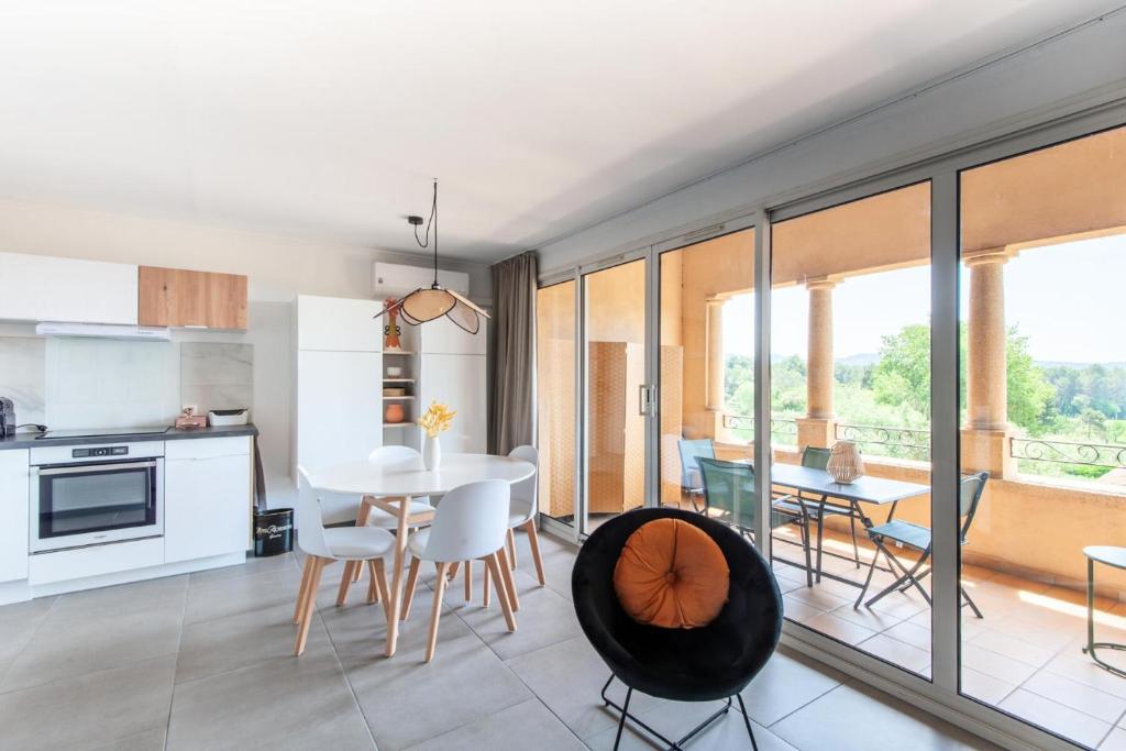 une cuisine et une salle à manger avec une table et des chaises dans l'établissement Village Pont Royal en Provence - maeva Home - Appartement cosy et climatisé 3 pièces 6 personnes - Prestige - super Home MAE-3914, à Mallemort