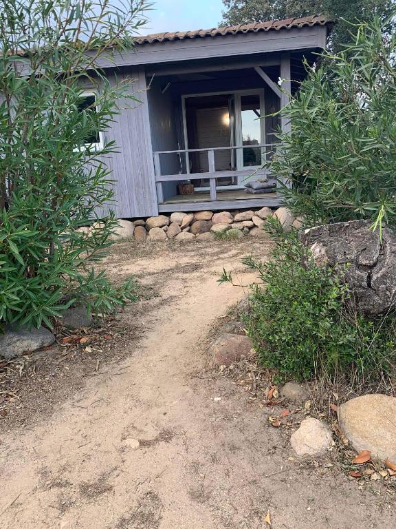 une maison avec un chemin de terre devant elle dans l'établissement La Petite Maison dans le Maquis, à Porto-Vecchio