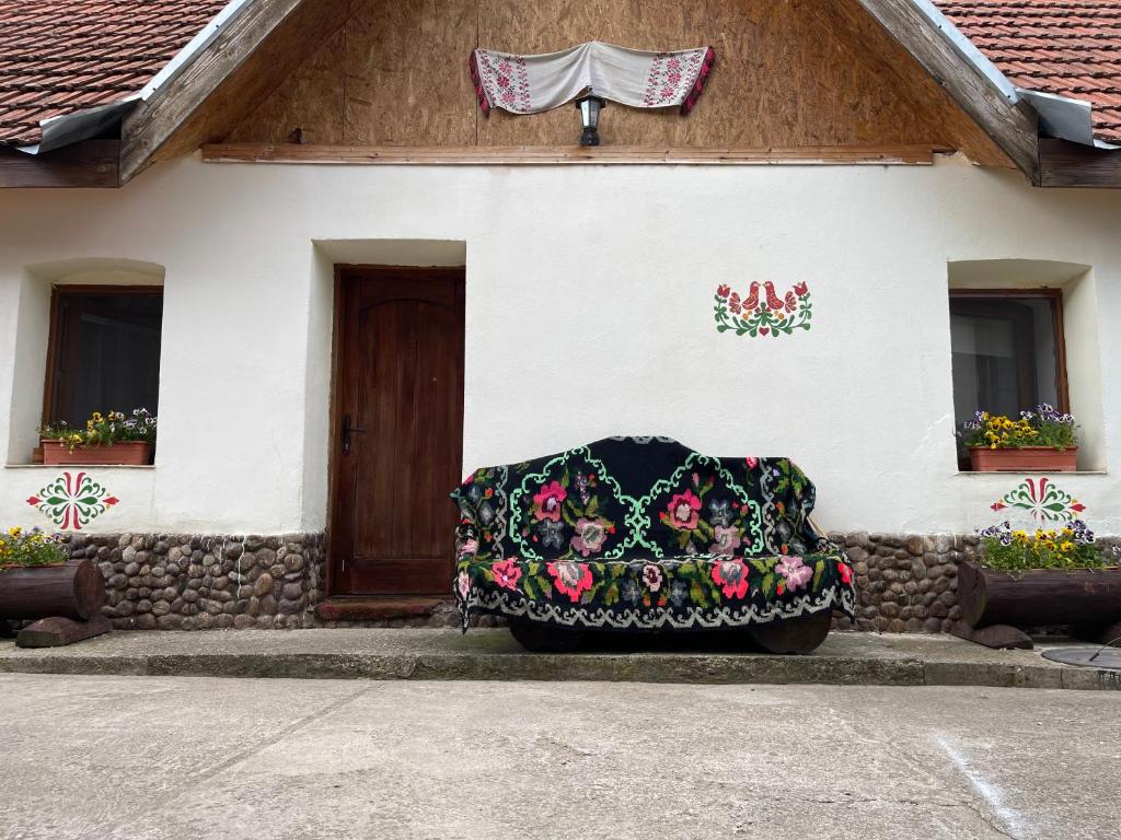 un bâtiment avec une couronne à l'avant dans l'établissement Casa bunicilor, à Nădăştia de Sus