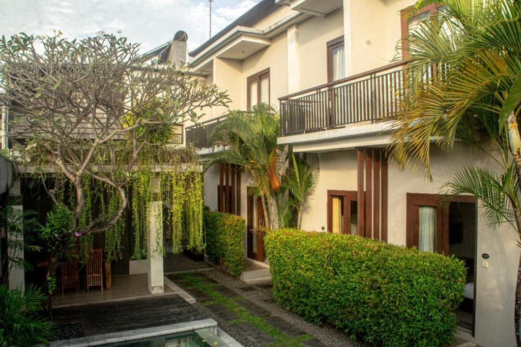 a building with trees and plants in front of it at Room Valka Bali Seminyak in Seminyak