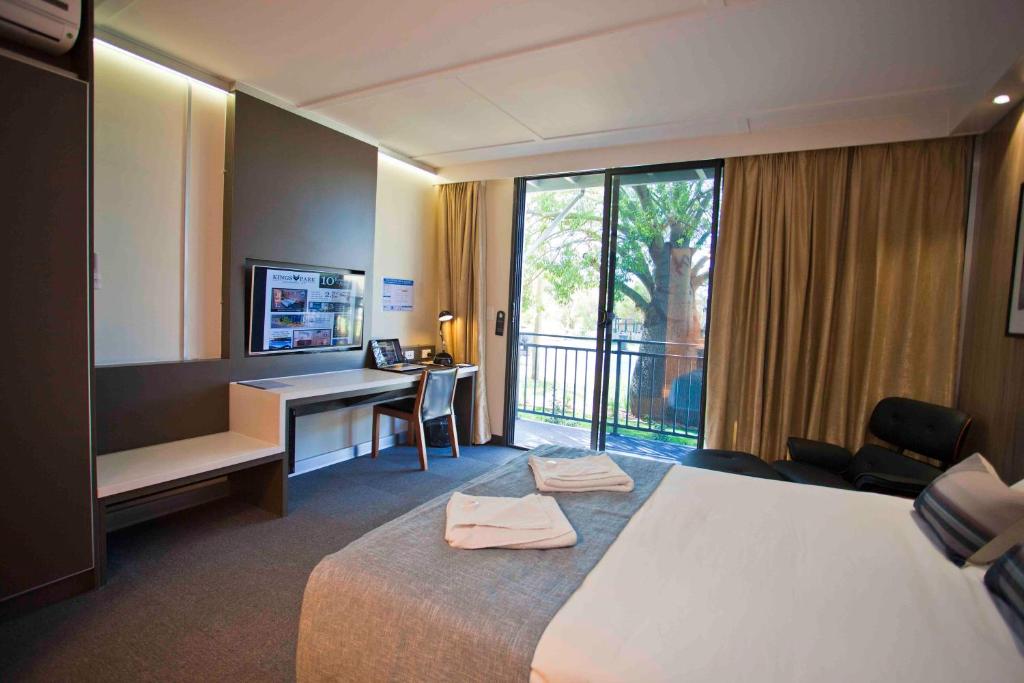 a hotel room with a bed and a desk and a window at Kings Park - Accommodation in Chinchilla