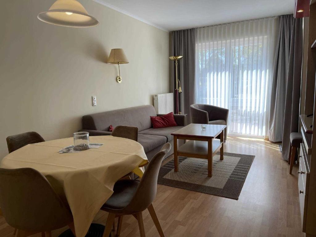 - un salon avec une table et un canapé dans l'établissement Haus Niedersachsen Apartment 8, à Timmendorfer Strand