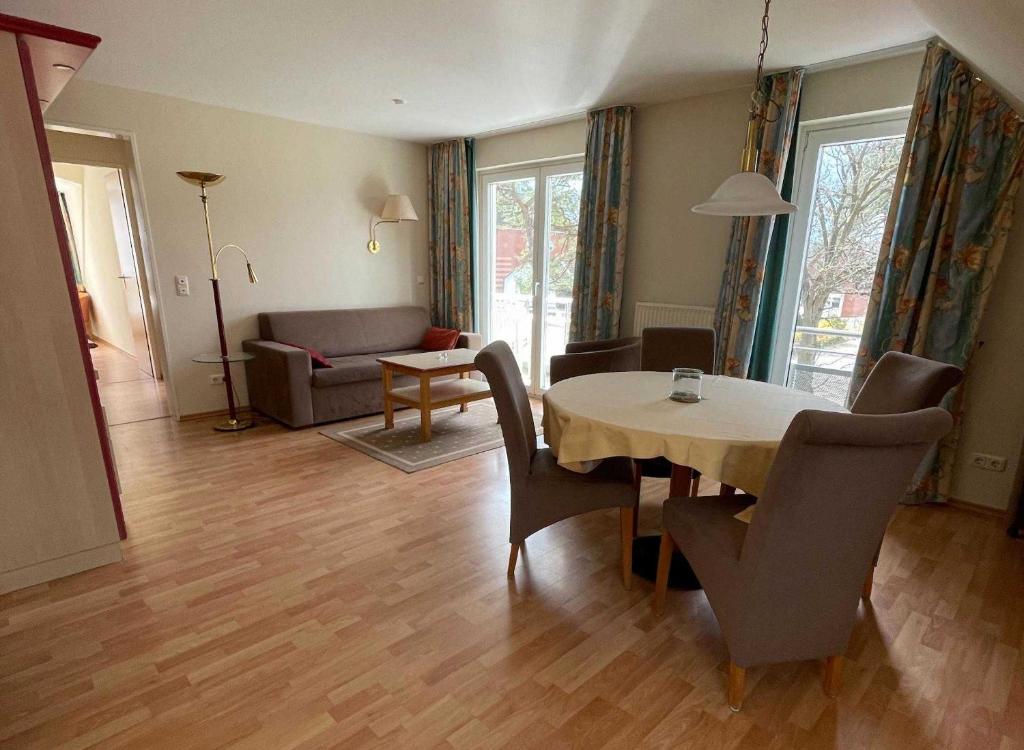 sala de estar con mesa, sillas y sofá en Haus Niedersachsen Apartment 11, en Timmendorfer Strand