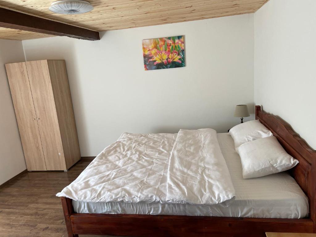 a bedroom with a bed and a painting on the wall at La Stermin in Viştea de Sus