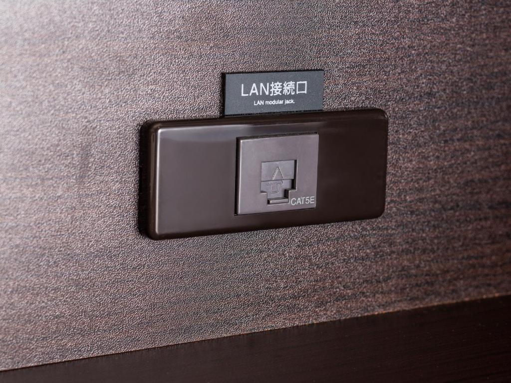 a lightswitch on the side of a wall at APA Hotel Haneda Anamori Inari Ekimae in Tokyo