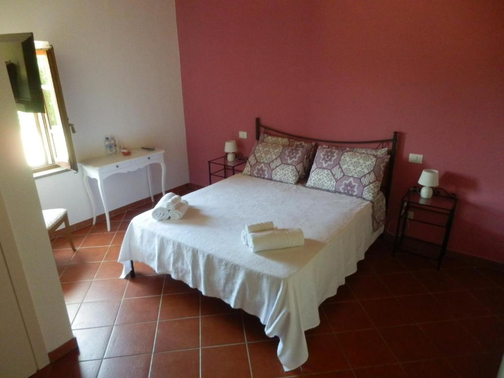 1 dormitorio con cama y pared roja en Il casale di Sandra, en Chiusi