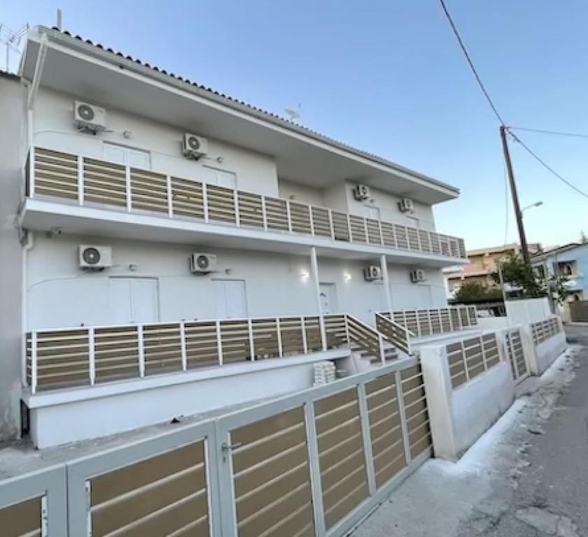 a white building with a fence in front of it at Bed and Beach in Ipsos