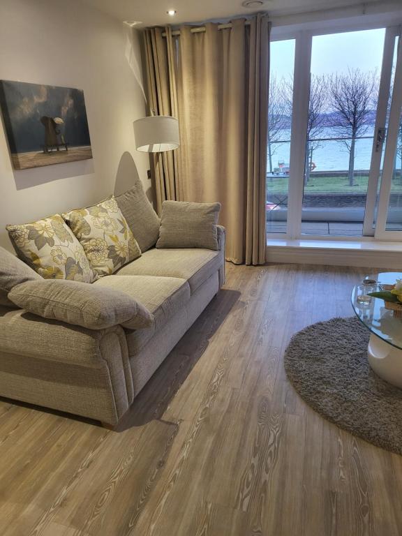 a living room with a couch and a large window at Waterfront apartment in Dundee