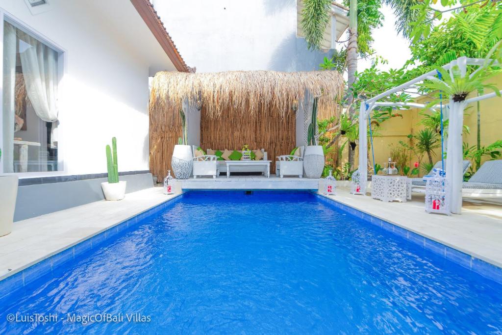een zwembad in een villa met een zithoek bij Smiling Cactus Villas Seminyak in Seminyak