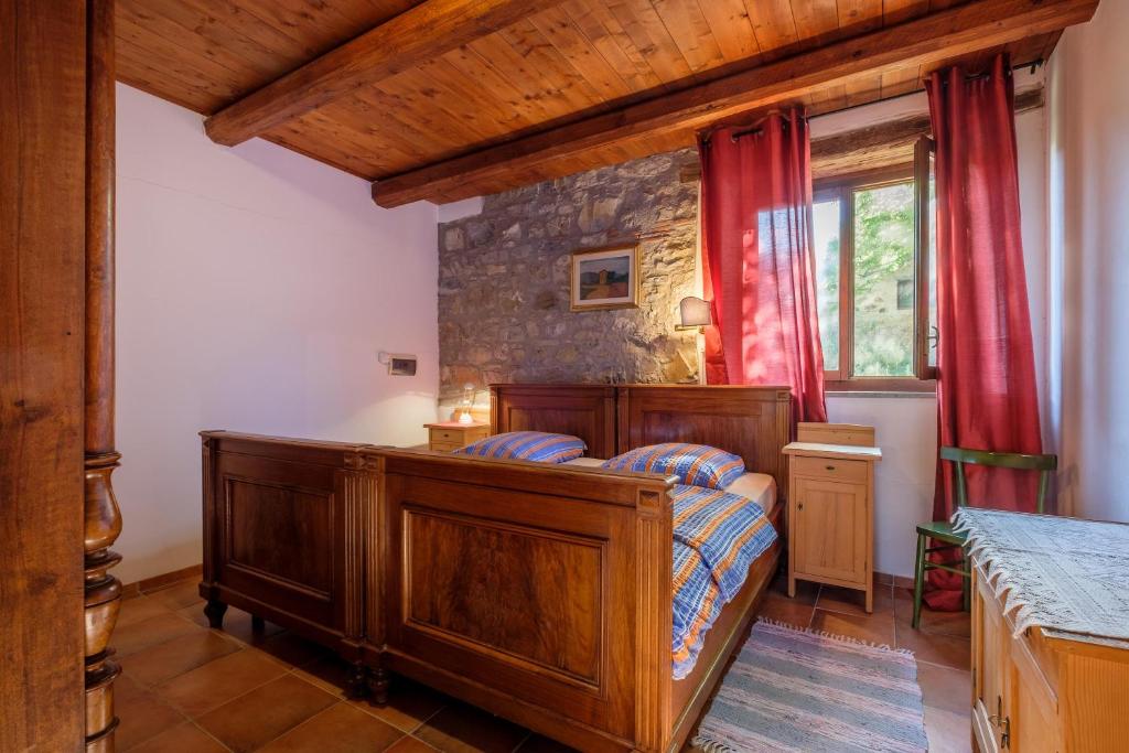 1 dormitorio con cama y cortina roja en Stella Nord Podere Carbone, en Grosseto