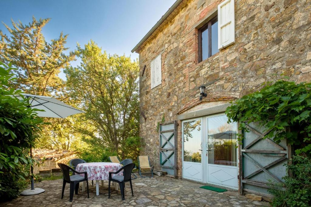 Un patio con una mesa y sillas frente a un edificio. en Antico Podere Carbone, en Grosseto