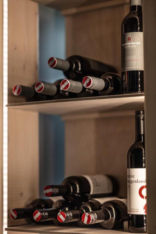 a bunch of bottles of wine sitting on a shelf at Pannonia Appartements 2 in Neusiedl am See