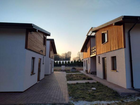 a group of buildings with a brick path between them at Austeria Zakościele in Inowłódz