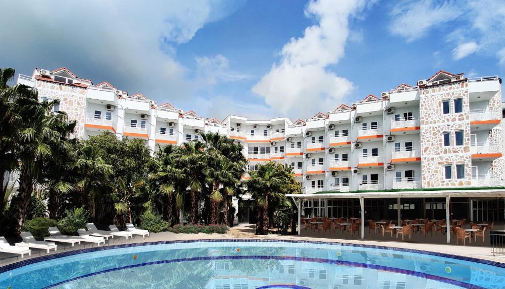 un hotel con piscina frente a un edificio en UK Hotel Kiriş en Antalya