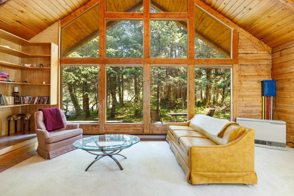 sala de estar con sofá y mesa de cristal en Alpine Meadows Log Cabin, en Girdwood