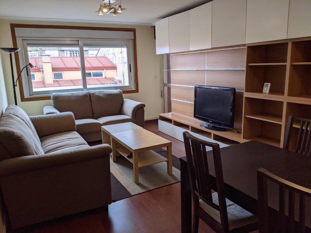 a living room with a couch and a television at Piso 4 habitaciones calle Barcelona in Vigo
