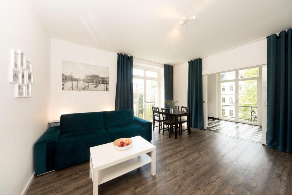 ein Wohnzimmer mit einer grünen Couch und einem Tisch in der Unterkunft L.E. Home II in Leipzig