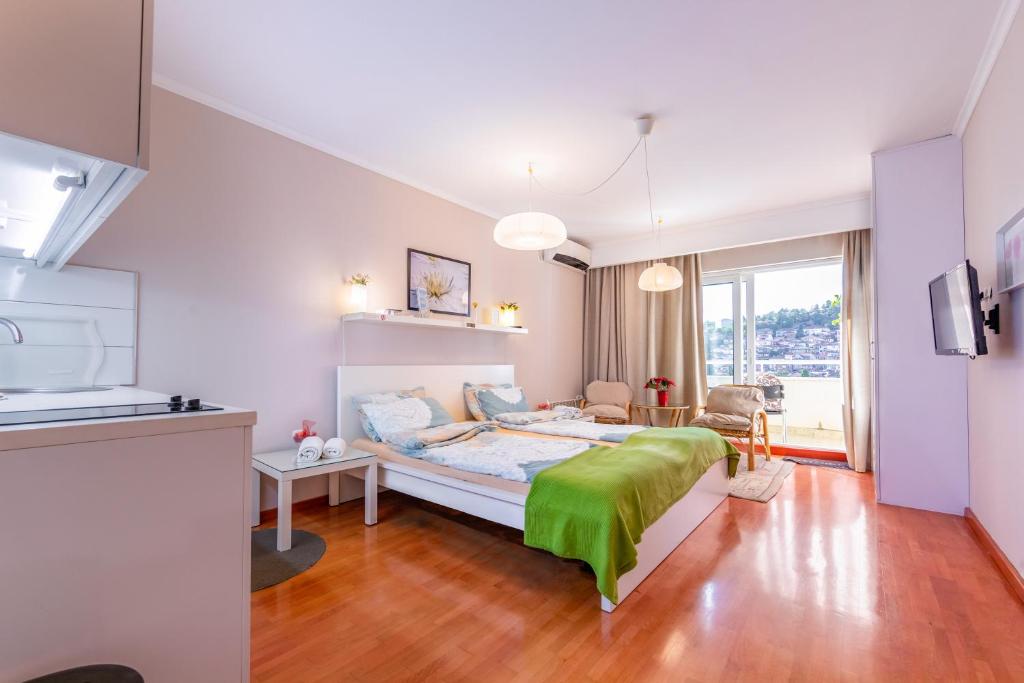 een slaapkamer met een groot bed en een groene deken bij Dimar Apartments in Ohrid