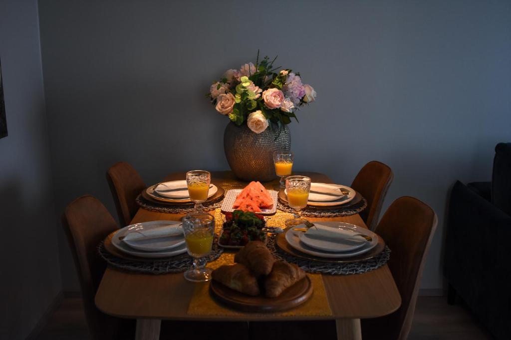 una mesa de comedor con un jarrón de flores y una mesa con platos en Hubane Olevi Apartment, en Võru
