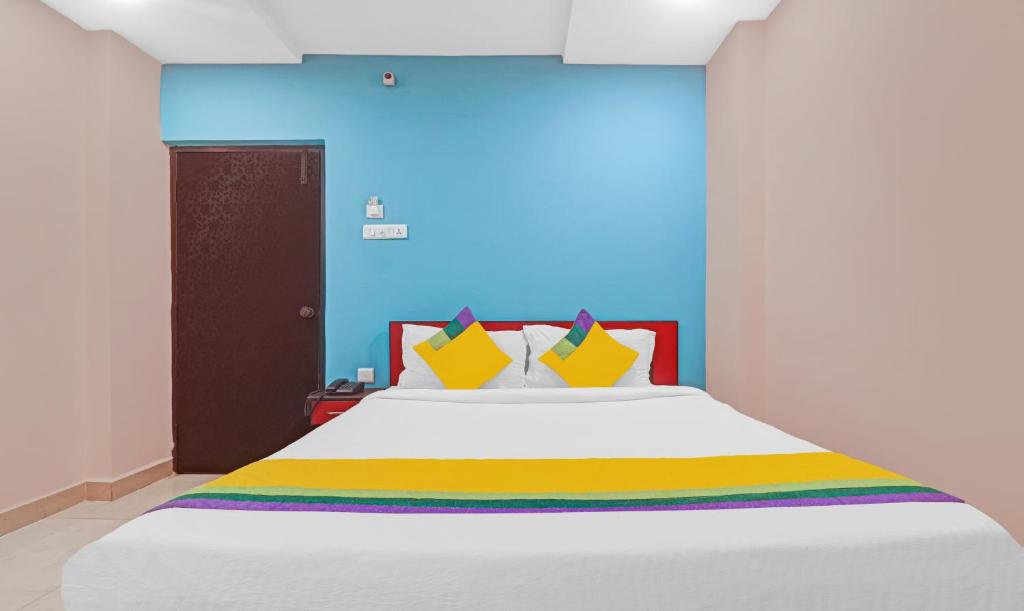 ハイデラバードにあるItsy Hotels Aflahのベッドルーム(大きな白いベッド、カラフルな枕付)