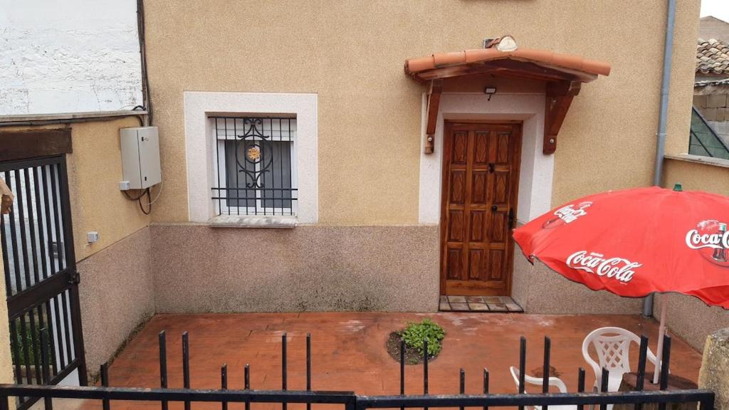um guarda-chuva vermelho e um edifício com uma janela em Casa Flor em Arcas
