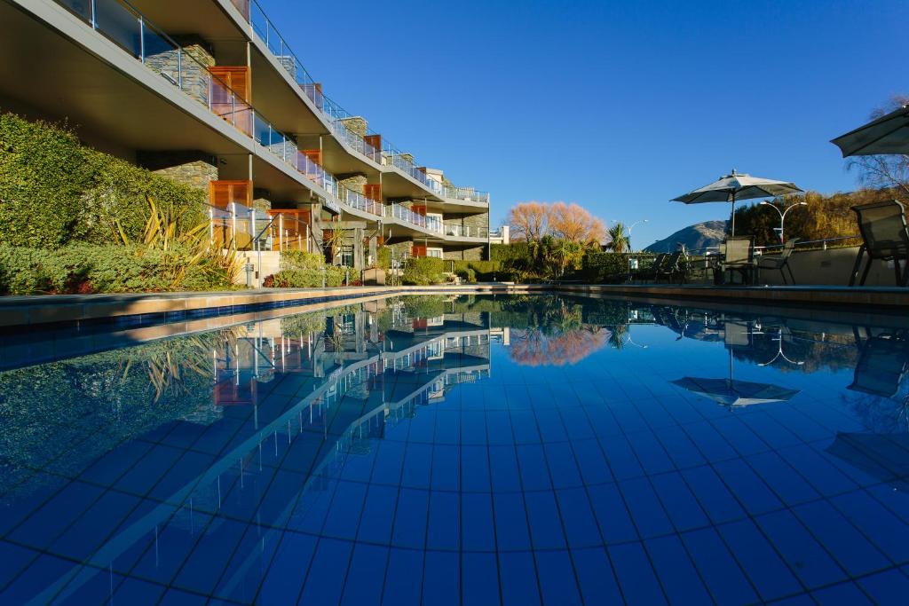 a swimming pool in front of a building at Lakeside Apartments in Wanaka