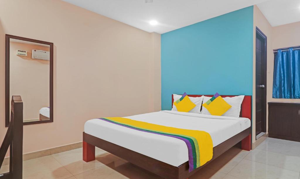 ハイデラバードにあるItsy Hotels Aflahのベッドルーム1室(カラフルな毛布付きのベッド1台付)