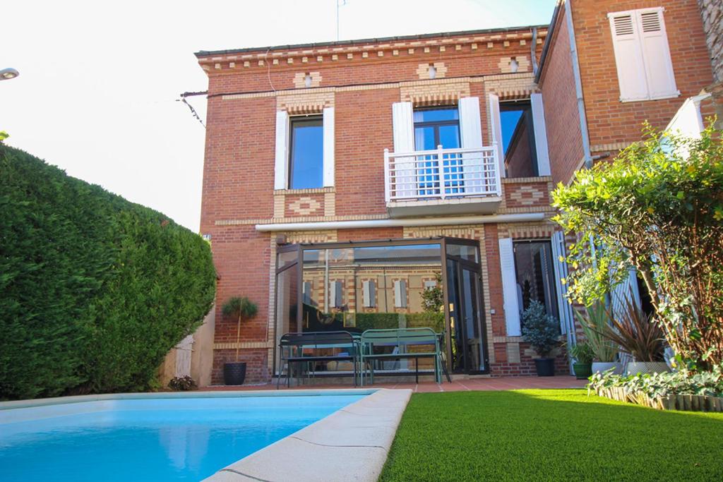 a brick house with a swimming pool in front of it at Evasion in Albi