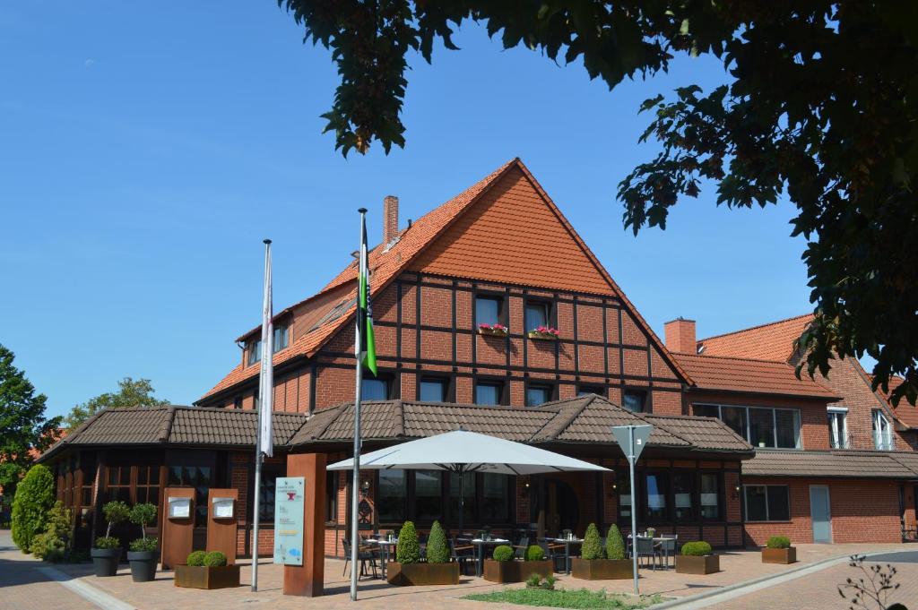um edifício com uma bandeira à sua frente em Romantik Hotel Schmiedegasthaus Gehrke em Bad Nenndorf
