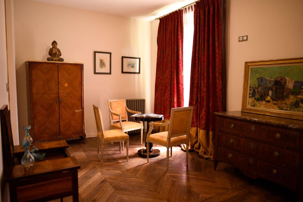 a living room with chairs and a table and a dresser at Château de Pymont in Boyer