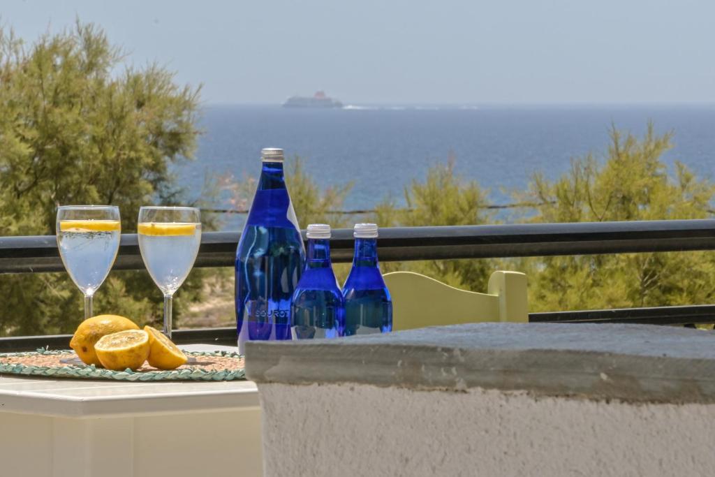 einen Tisch mit zwei Gläsern Wein und Orangen in der Unterkunft Studios Tasia in Agios Prokopios
