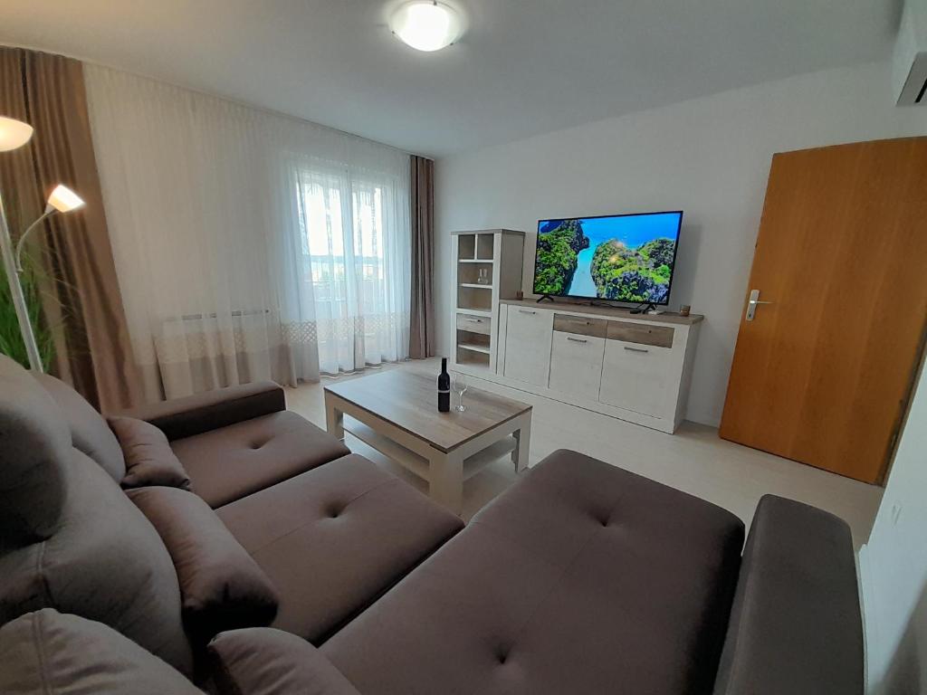 a living room with a couch and a tv at Apartments Portoroz - Beautiful Street in Portorož