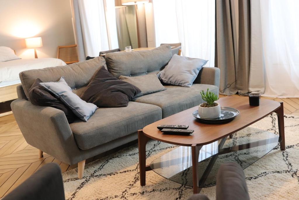 a living room with a couch and a coffee table at Le Mans Hypercentre - proche place République in Le Mans