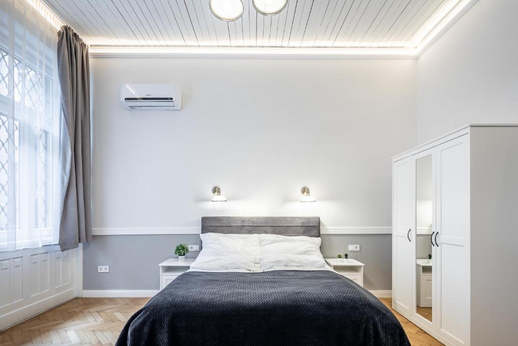 ein Schlafzimmer mit einem Bett mit einer schwarzen Decke in der Unterkunft Luxurious Apartments At City Center in Budapest