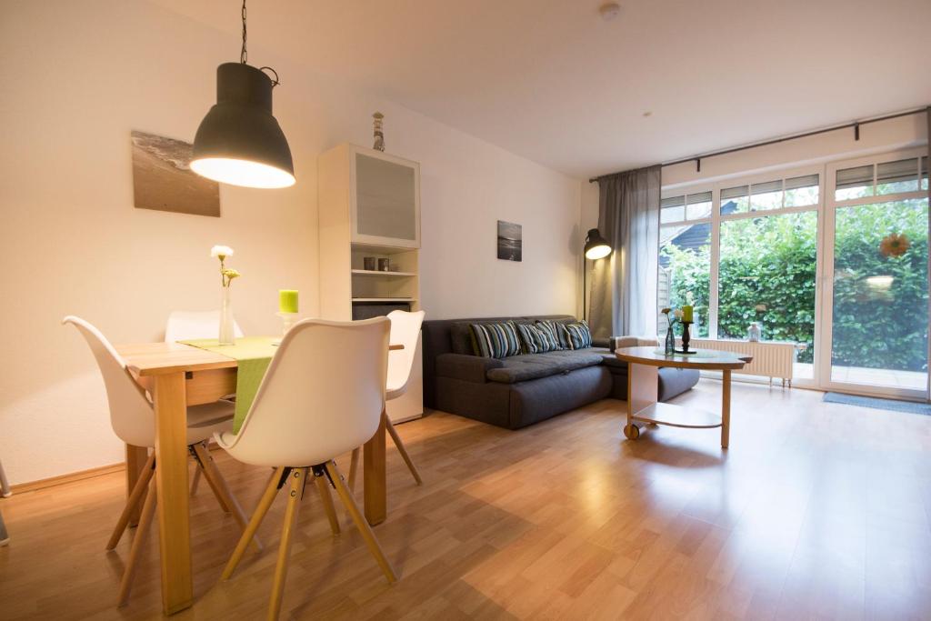 uma sala de estar com uma mesa e um sofá em Ferienwohnung am Swatten Diek 36 FeWo 2 em Cuxhaven