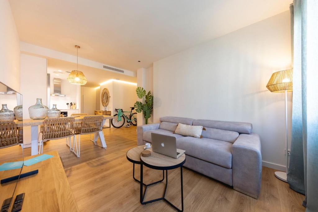 a living room with a couch and a table with a laptop at Bravissimo Gerió, 2-bedroom apartment in Girona