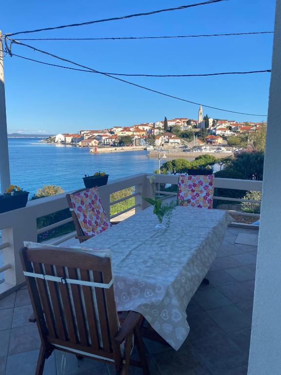 a table on a balcony with a view of the water at Apartman Ana Kali in Kali