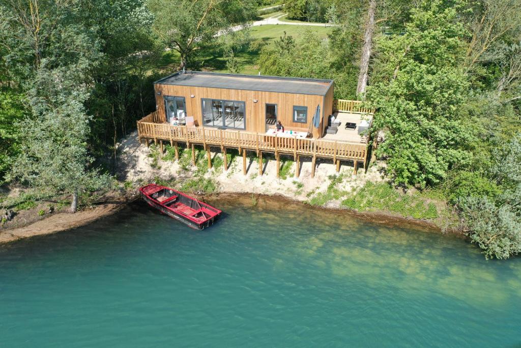 une maison sur un quai avec un bateau dans l'eau dans l'établissement Les Etangs de la Bassée, à Gravon