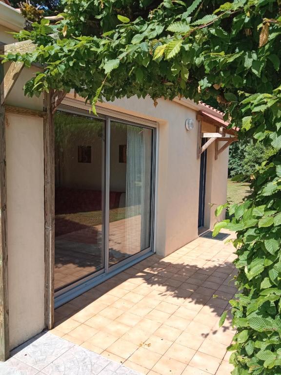 a sliding glass door on a house with trees at Gîte 2 personnes, proche mer in Challans