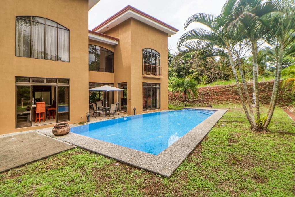 Villa con piscina frente a una casa en Esterillos Estates Coconut 38, en Esterillos