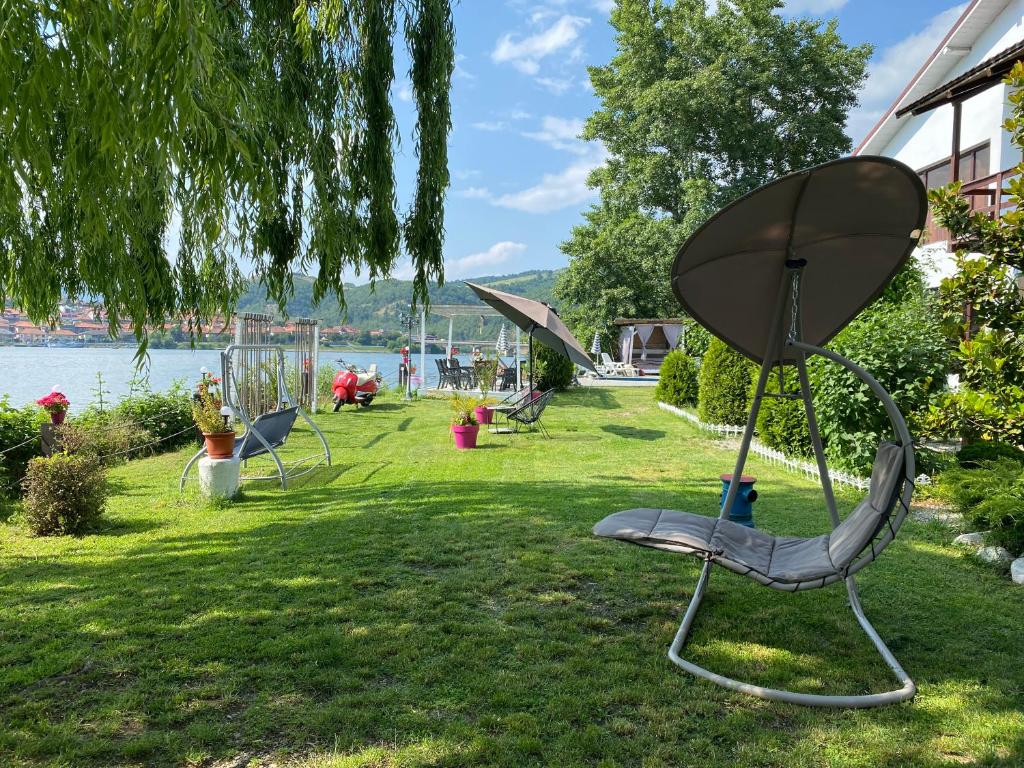 a group of chairs sitting on the grass near the water at CHALET Orsova in Orşova