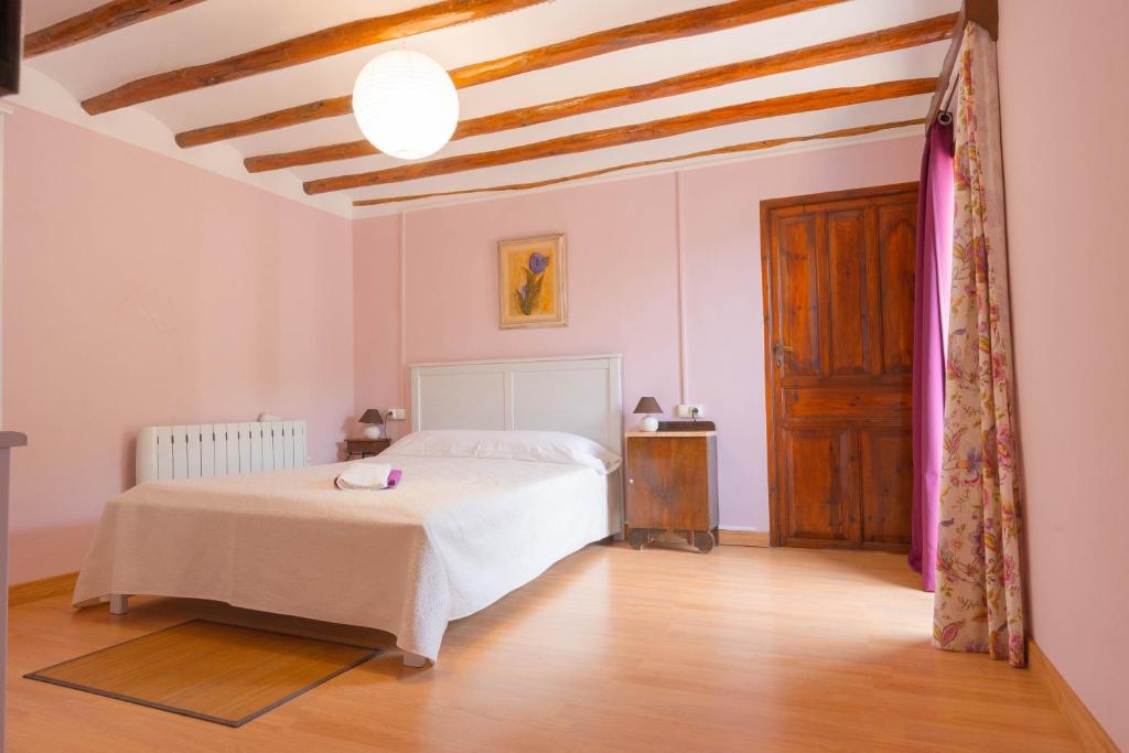 1 dormitorio con cama blanca y suelo de madera en Masia Rural Canalisos, en Adzaneta