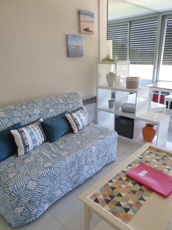 ein Wohnzimmer mit einem Sofa und einem Tisch in der Unterkunft Athéna Résidence Bandol - Piscine et Tennis in Bandol