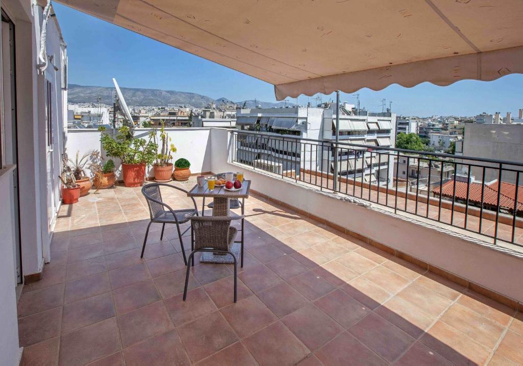 a balcony with a table and chairs on a roof at Rooftop apartment with great veranda in Athens