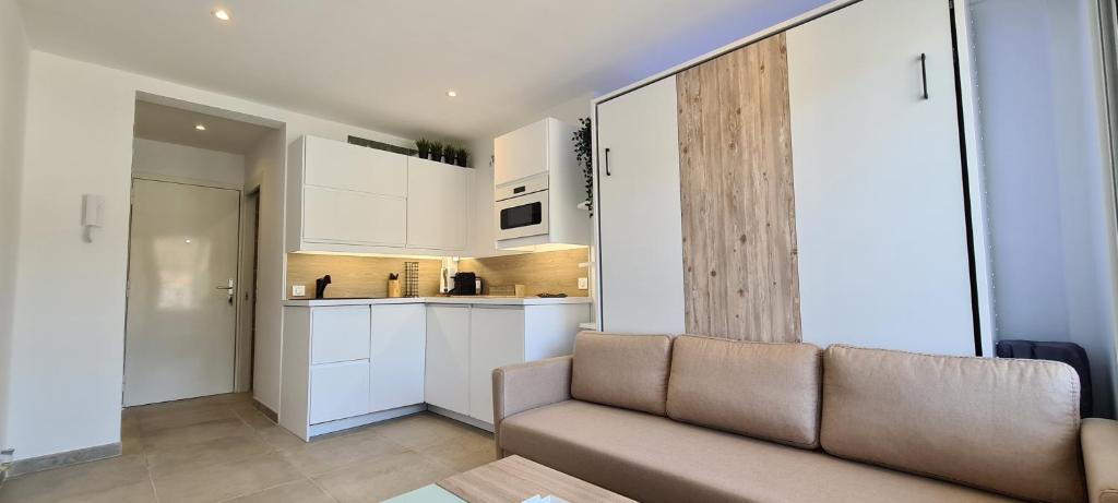 Hotel Studio Cannes, a living room with a couch and a kitchen at Studio Cannes in Cannes