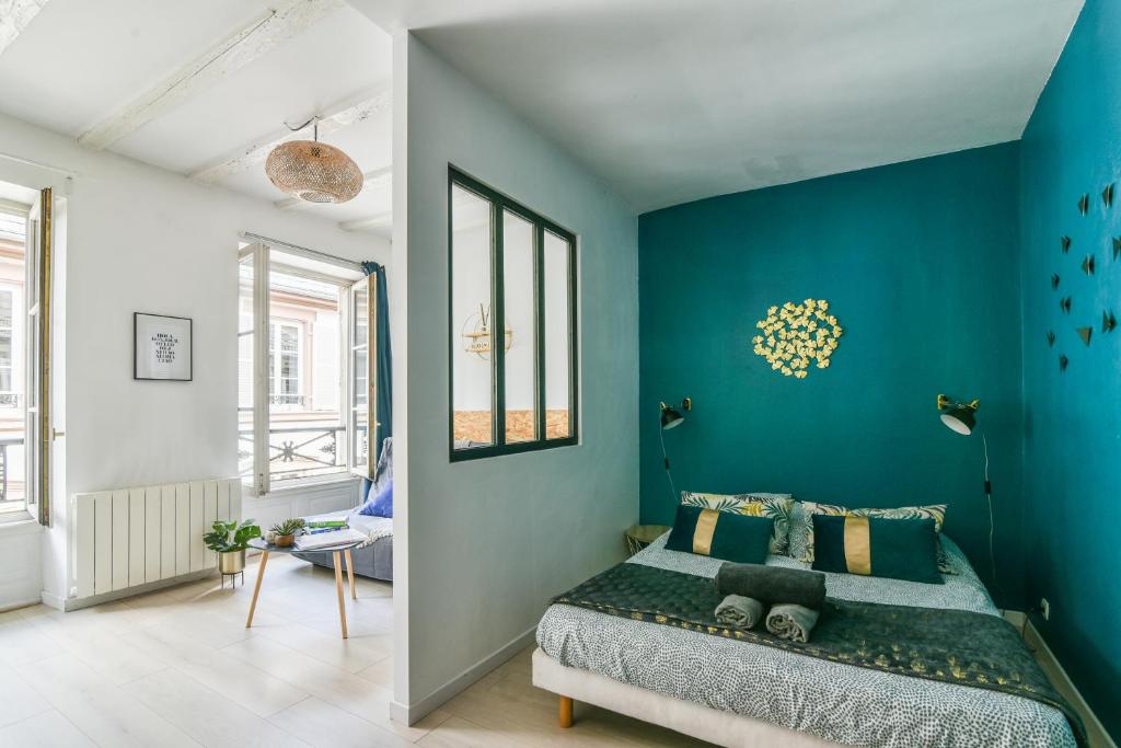 Un dormitorio con una pared de acento azul y una cama en R-Appartements Fenetresurkrut appartement cosy centre-ville Strasbourg, en Estrasburgo