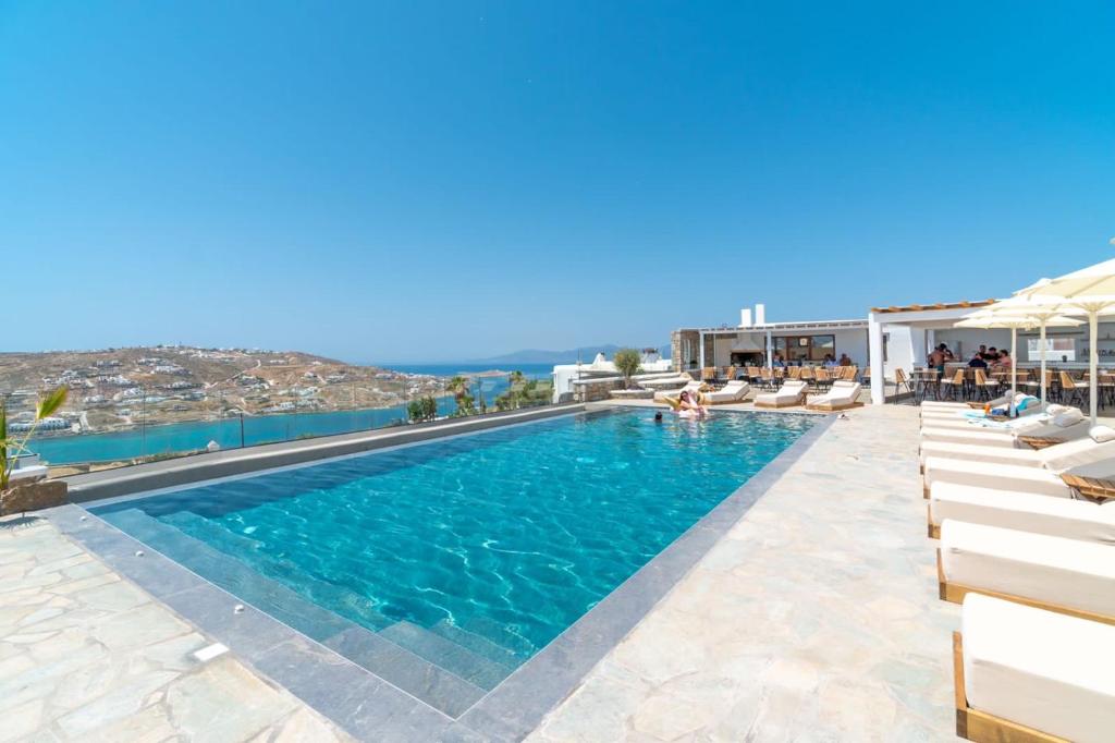 einen Pool in einem Hotel mit Stühlen und Aussicht in der Unterkunft IL Vento Premium in Mykonos Stadt
