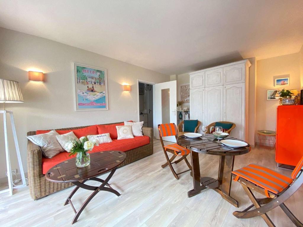 un salon avec un canapé rouge et une table dans l'établissement Appartement 2 pièces avec terrasse, garage, et ascenseur, jusqu'à 4 couchages - La Baule Centre - FR-1-245-124, à La Baule