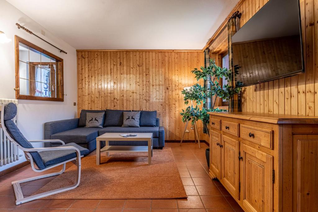 a living room with a blue couch and a table at Villetta Campiglio in Madonna di Campiglio