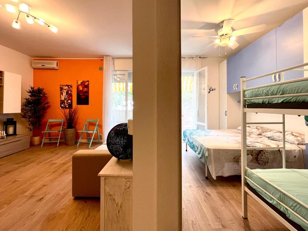 Grazioso Appartamento con Piscina e Terrazza في بورتو سانتا مارغريتا دي كاورل: غرفة مع سرير بطابقين وغرفة نوم مع جدران برتقالية